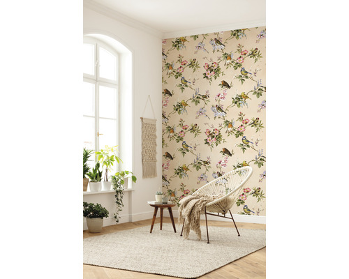 Cameră luminoasă cu tapet floral, scaun rotund și plante de interior