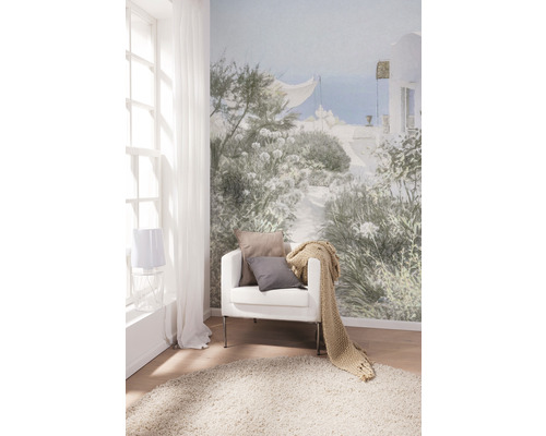 Cameră de zi cu fototapet, fotoliu, perne, cuvertură și covor pentru o atmosferă luminoasă și prietenoasă.