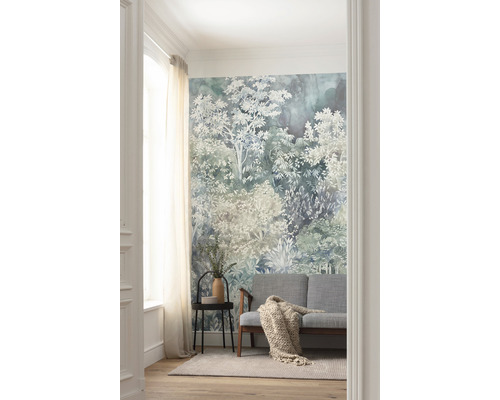 Cameră de zi cu tapet cu pădure, canapea, măsuță laterală și covor.