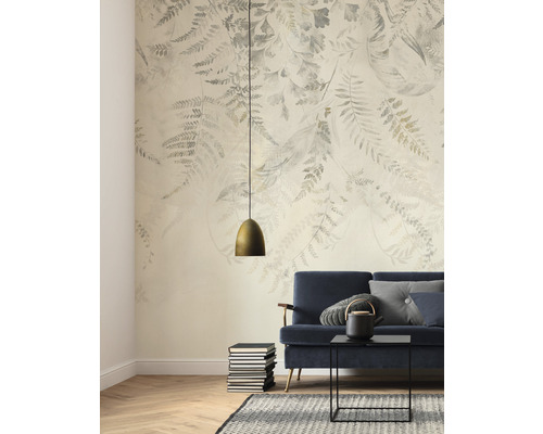 Cameră de zi cu fototapet cu motive vegetale, canapea, masă și lampă