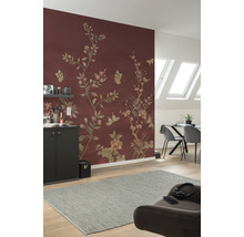 Living cu tapet cu model floral în maro roșcat, masă de sufragerie, scaune și covor gri.