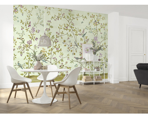 O sală de mese cu tapet cu model de păsări și flori, o masă și scaune.
