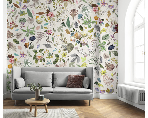 Cameră de zi cu canapea și tapet floral cu frunze și flori.