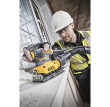 Artizan șlefuiește rama ferestrei cu o șlefuitoare orbitală DeWalt