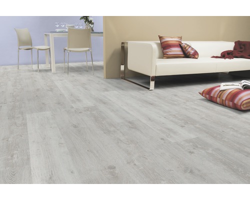 Pardoseală laminată deschisă la culoare într-un living cu canapea și zonă de luat masa.