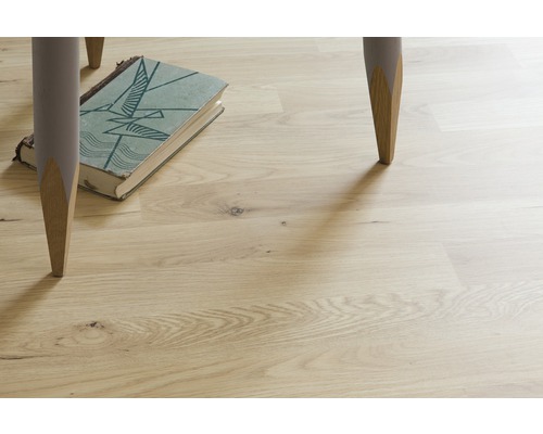 Podea deschisă la culoare din lemn cu picioare de masă și carte