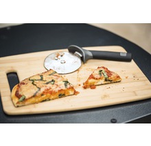 Două felii de pizza și un cuțit de pizza pe un tocător de lemn