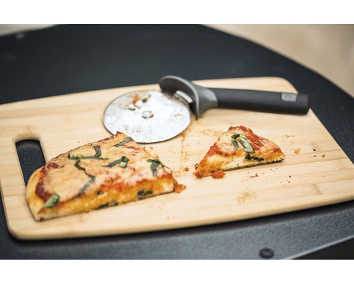 Două felii de pizza și un cuțit de pizza pe un tocător de lemn