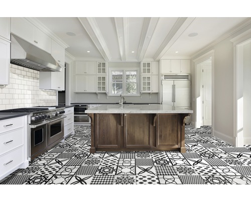 Bucătărie luminoasă cu insulă de bucătărie, dulapuri albe și gresie cu modele geometrice.