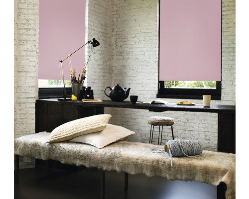 Cameră luminoasă cu două ferestre și jaluzele roz, decorată cu o bancă, o masă și accesorii