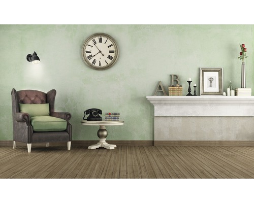 Living cu fotoliu, ceas și decorațiuni pe șemineu