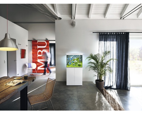 Cameră de zi cu acvariu pe dulap inferior, masă de sufragerie și perdele