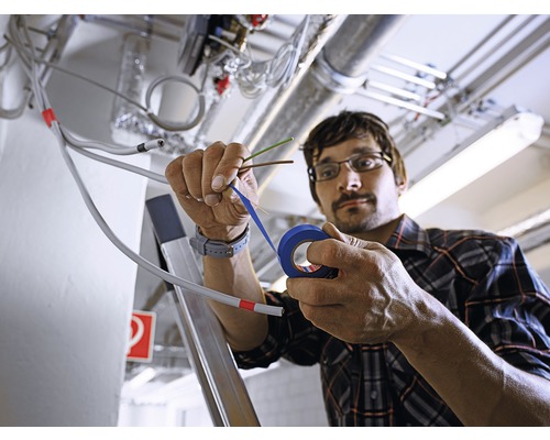 Electrician izolând cabluri cu bandă izolatoare