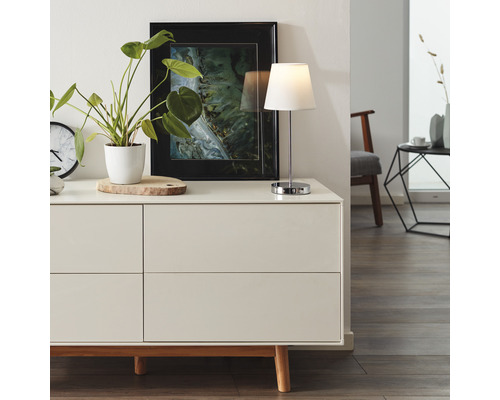 Cameră de zi modernă cu comodă, lampă de masă și decorațiuni