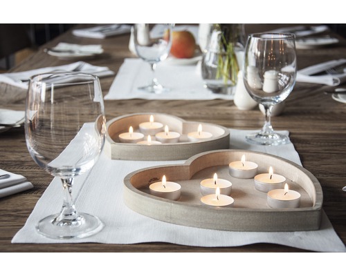 Decorațiuni de masă cu lumânări tip pastilă în suporturi în formă de inimă și pahare de vin