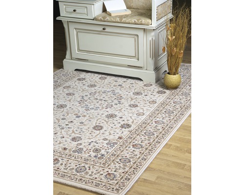 Covor decorativ cu model floral în fața unui dulap pe o podea de lemn