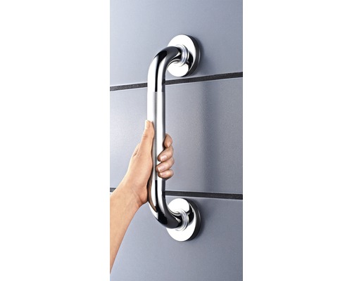 O mână ține o bară de sprijin metalică fixată pe un perete.