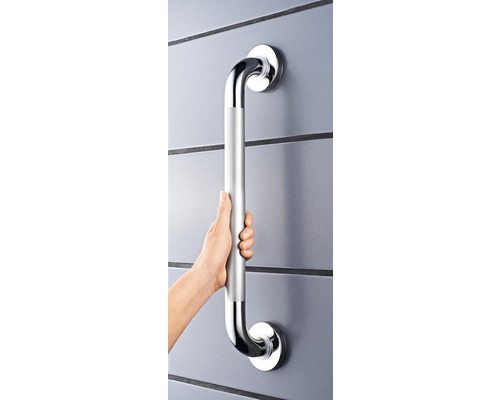 Persoană ține un mâner argintiu pe un perete