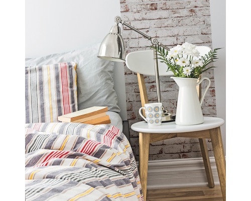 Dormitor decorativ cu pat, noptieră, lampă și flori