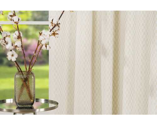 Panou decorativ din material textil cu model și ramură de bumbac într-o vază pe o masă