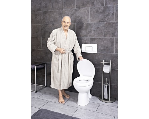 Baie cu toaletă fixă și o persoană în halat de baie