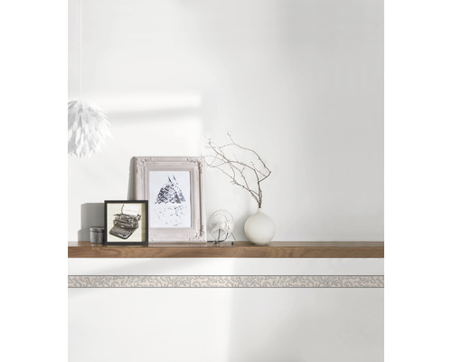 Bordură decorativă pe un perete deasupra unui raft cu decorațiuni