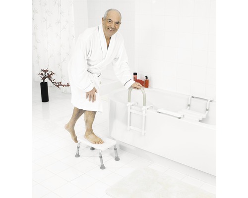 Bărbat în halat de baie folosind ajutor pentru intrarea în cadă, scândură pentru cadă și scaun de baie în baie.