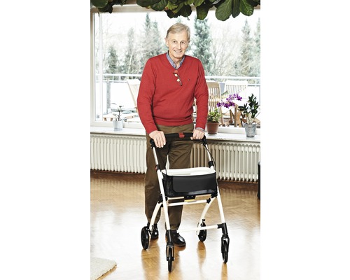 Bărbat cu cadru de mers într-o cameră de zi luminoasă.