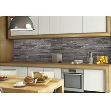 Scenă de bucătărie cu un panou de protecție cu aspect de piatră în spatele blatului de lucru