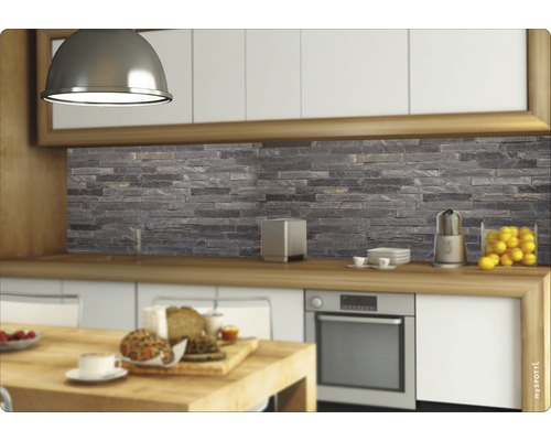 Scenă de bucătărie cu un panou de protecție cu aspect de piatră în spatele blatului de lucru