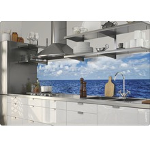 Bucătărie luminoasă cu hotă din oțel inoxidabil, dulapuri albe și vedere la mare