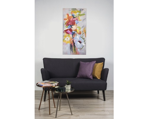 Living cu canapea, măsuțe laterale și un tablou cu motiv floral.