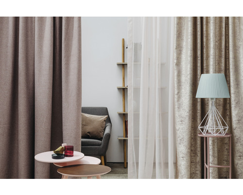 Scenă decorativă de sufragerie cu perdele, fotoliu, masă și lampă