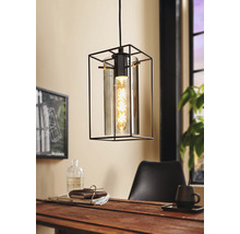 Lampa suspendată cu design geometric din metal și sticlă deasupra unei mese din lemn