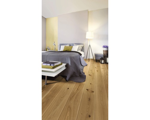 Dormitor luminos cu podea din lemn, pat și noptieră