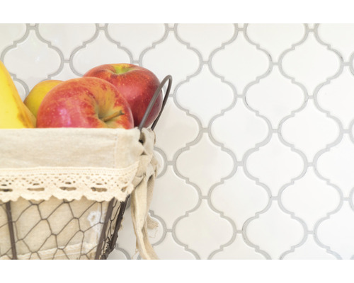 Perete decorativ din faianță cu coș de fructe în prim-plan.