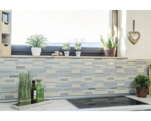 Scenă de bucătărie cu mozaic de faianță pe perete, pervaz cu decorațiuni și plită pe blat.