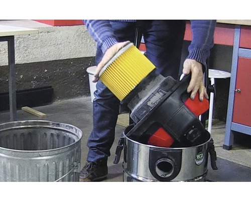 Persoană care aruncă filtrul unui aspirator într-un coș de gunoi