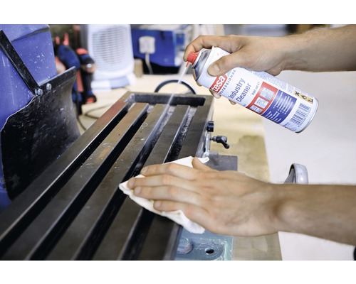 O persoană curăță un banc de lucru cu Tesa Industry Cleaner.