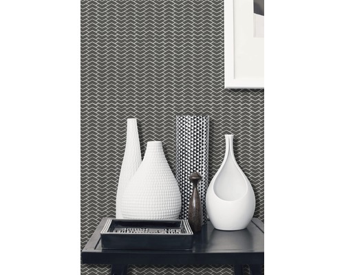 Cameră de zi decorativă cu tapet cu model, diverse vaze și o tavă dreptunghiulară pe o masă.