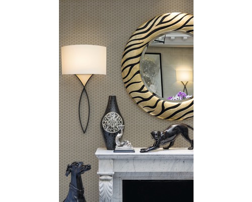 Șemineu decorativ cu oglindă, lampă și figurine decorative pe un fundal de mozaic.