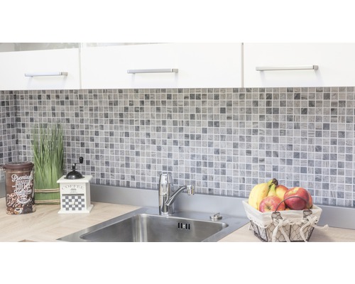 Scenă de bucătărie cu plăci de mozaic, chiuvetă și elemente decorative.