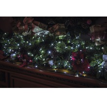 Șemineu decorat cu ghirlandă, lumini și decorațiuni de Crăciun