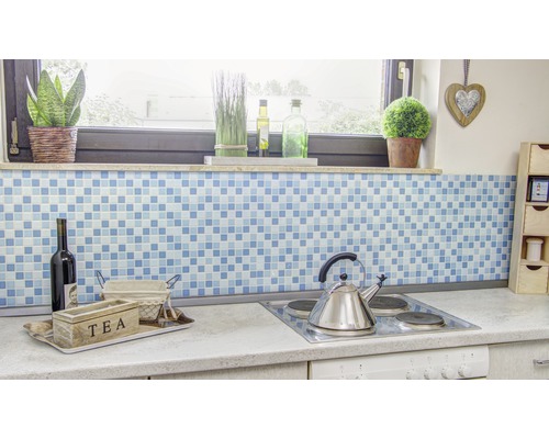 Scenă de bucătărie cu fundal mozaic albastru, cutie de ceai, sticlă de vin și plită