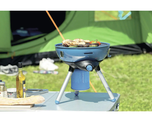 Grătar de camping cu alimente în fața unui cort