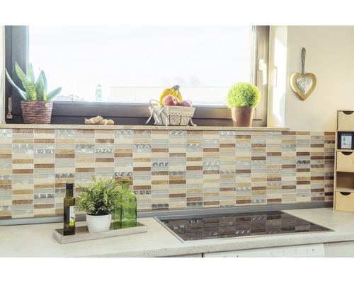 Scenă de bucătărie cu gresie mozaic pe perete, blat cu plante și plită