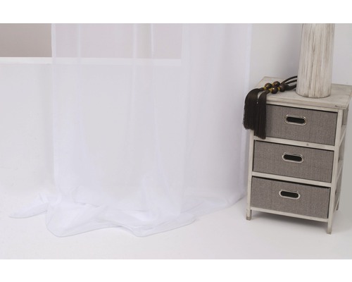 Cameră decorativă cu perdea albă, transparentă și comodă cu trei sertare