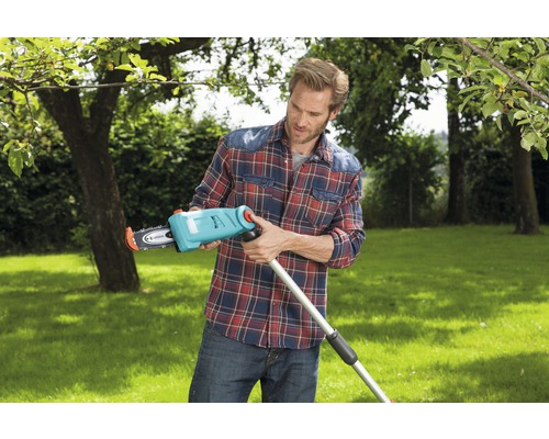 Bărbat asamblând un fierăstrău telescopic în grădină