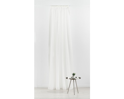 Șaluri decorative din țesătură de voal lângă o măsuță laterală cu plantă.