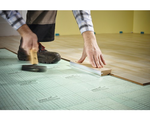 Instalare laminat cu ciocan și bloc de impact pe izolație fonică.